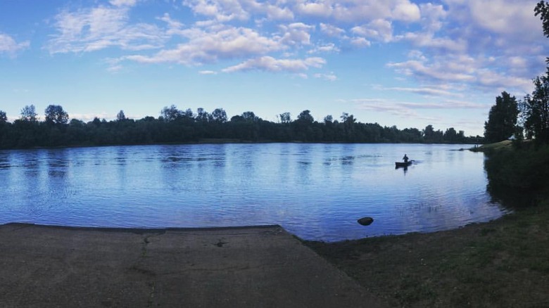 A person canoes along a river