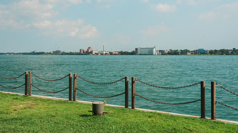 A view of the water from a grassy shore in Milliken State Park, Detroit, Michigan