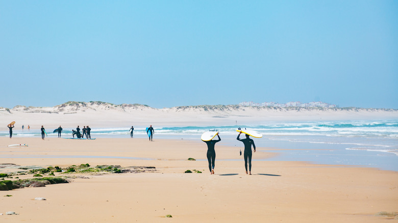 Surfers with surfboards walking along one of Baleal's beaches