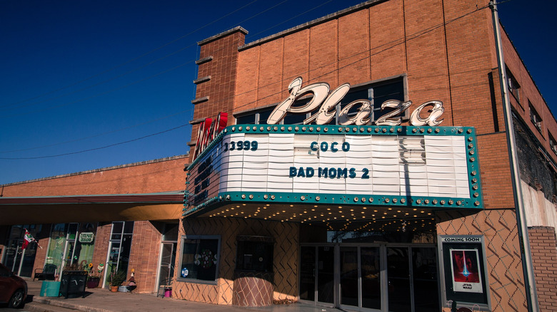 Red brick building with white theater marquee under blue sky
