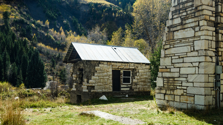Old buildings in Marble Colorado, with window panes and chunks of marble on the outside