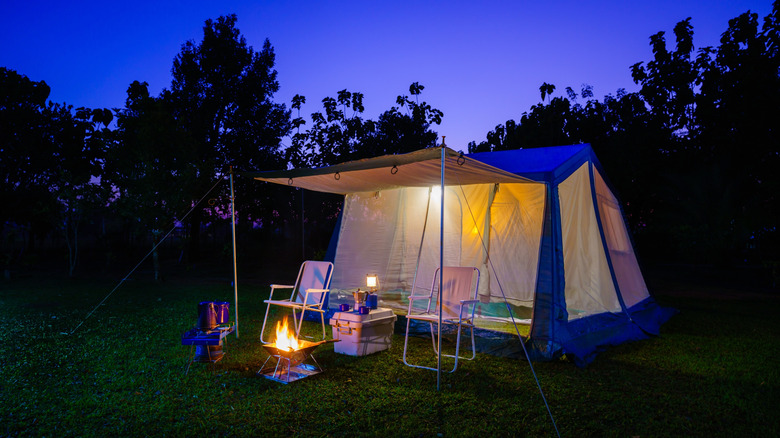 A camping tents stands quietly beneath the night sky