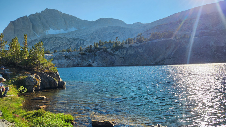 A picture of the sun shining on Steelhead Lake with rocky peaks alongside it