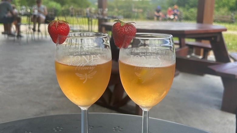 Specialty wines with strawberry garnishes in courtyard