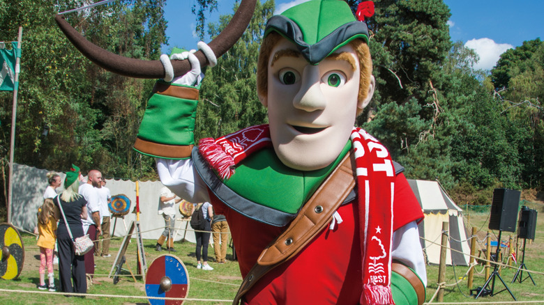 A Robin Hood mascot standing in front of families at an archery competition in Edwinstowe, England