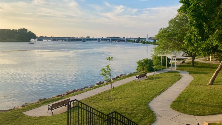 Paths and benches in Voyageur Park overlook Fox River and a bridge in De Pere, Wisconsin