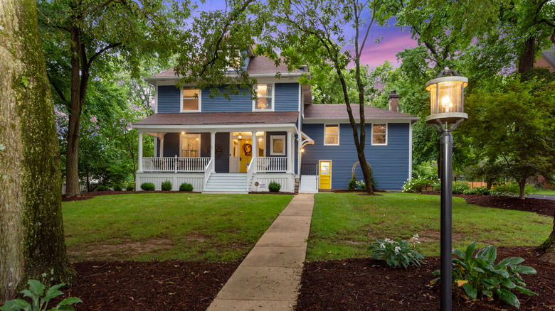 A warmly lit home surrounded by trees