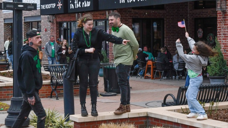 People standing and eating on Rose District's wide sidewalks