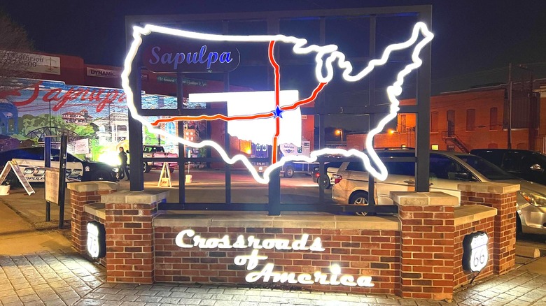 A neon sign showing US 66 and US 75 meeting in Sapulpa, Oklahoma with the nickname Crossroads of America