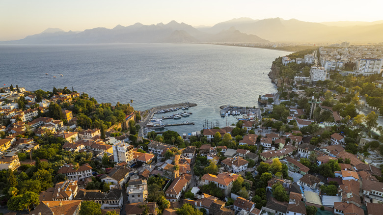 An overhead view of a harbor at sunset with mountains in the distance