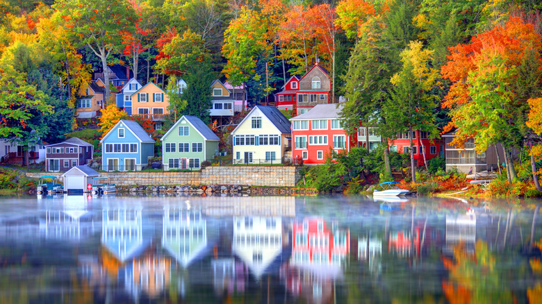 Colourful houses set on Lake Winnipesaukee, fringed by red, orange, and yellow trees