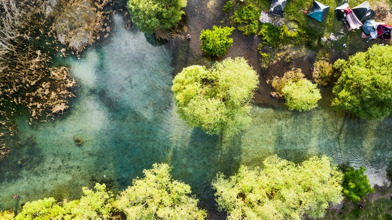 Top-down view of a river and tents on the shore