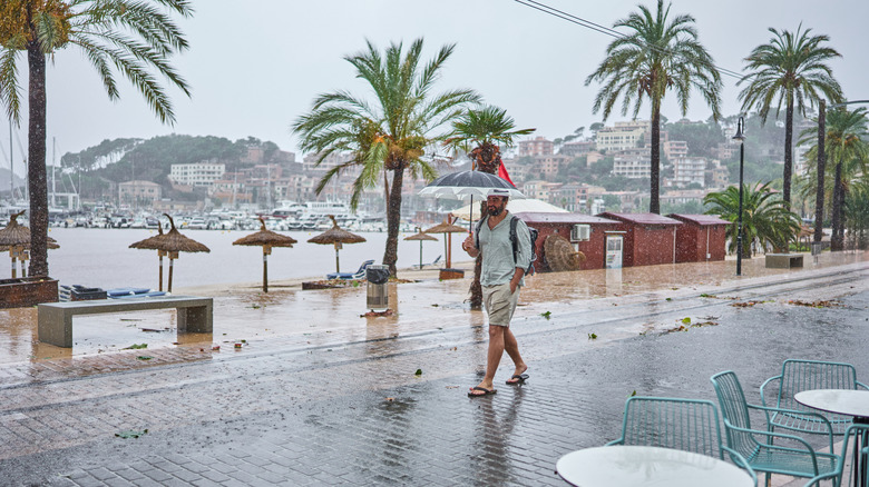 A man walking in the rain with an umbrella in Mallorca, Spain