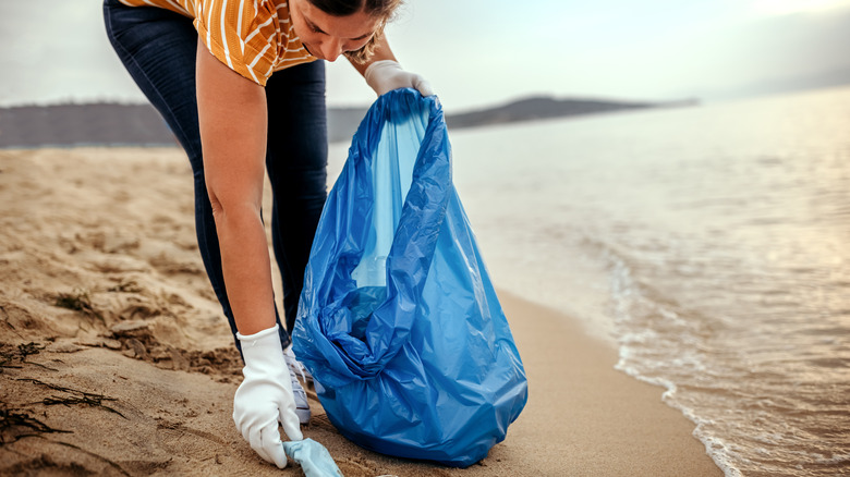 Person cleaning trash on beach