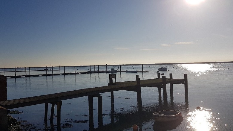 The sun shimmers over a pier and river in Burnham-on-Crouch