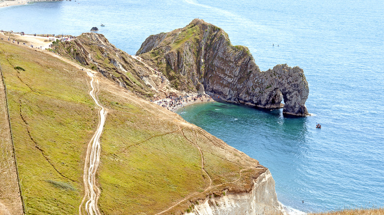 The dramatic rock arch of Durdle Door pokes out into clear blue waters