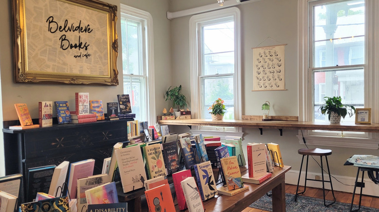 books arranged on a table beside barstools in Belvidere Books and Cafe where visitors can have coffee