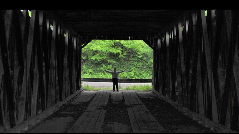 Man standing at the far end of the Historic Brown Covered Bridge