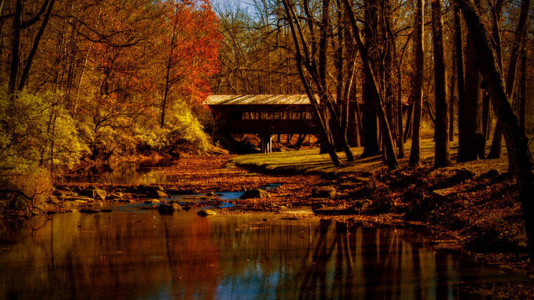 The Ross Covered Bridge across the Great Miami River in Tawawa Park in Sidney, Ohio, surrounded by fall foliage