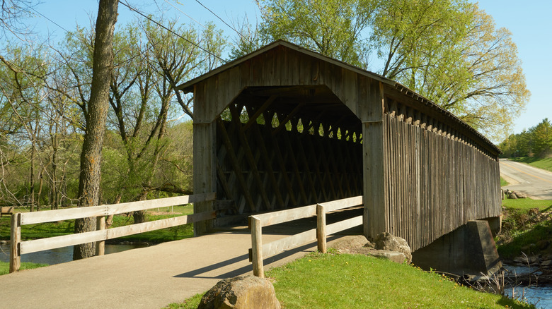 A historic wooden covered bridge crosses a creek at Covered Bridge County Park in Cedarburg