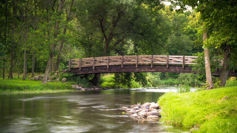 Calm water flows beneath a wooden bridge at Covered Bridge County Park in Wisconsin