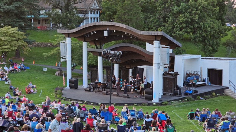 Rose Tree County Park hosting its annual summer festival, with a concert taking place at the amphitheater and people sitting on the lawn