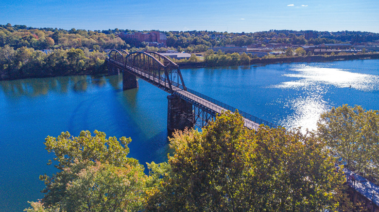 McKeesport Connecting Railroad Bridge over the Monongahela River, with the town of McKeesport on the far bank surrounded by trees, under a blue sky