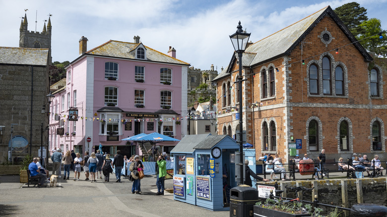 A busy day on the town quay, with historic buildings and crowds wandering in Fowey, England