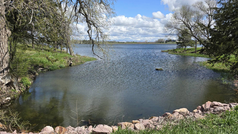 Lake bordered by trees at Mitchell Indigenous Archaeological Site & Museum in South Dakota