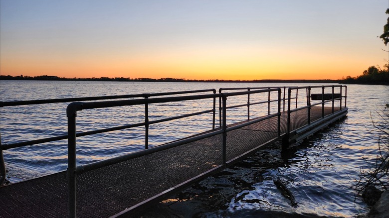 Metal pier extending over the water during sunset at Richey Cove, Council Grove Lake, Kansas