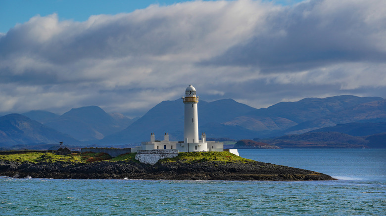 Lismore Lighthouse with mountains in the background, located on the small island Lismore in Scotland
