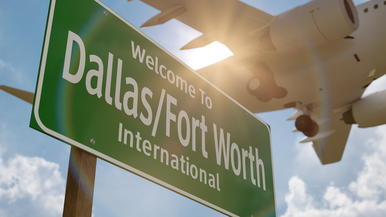 Welcome to Dallas - Fort Worth International Airport green road sign with airplane flying over it