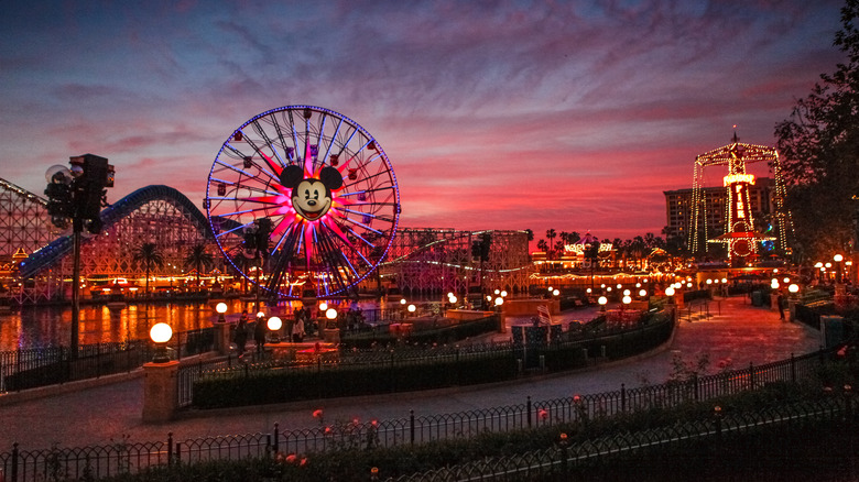 Tourists wander around Disney's California Adventure Park at dusk