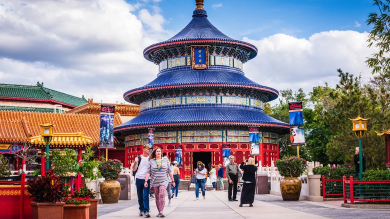 Tourists walking in front of a Chinese inspired building in Epcot
