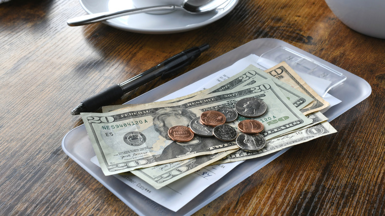 A cafe bill with American currency on a table