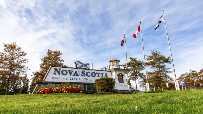 An inviting view of the Nova Scotia Welcome Center with flags and scenic surroundings under a bright sky