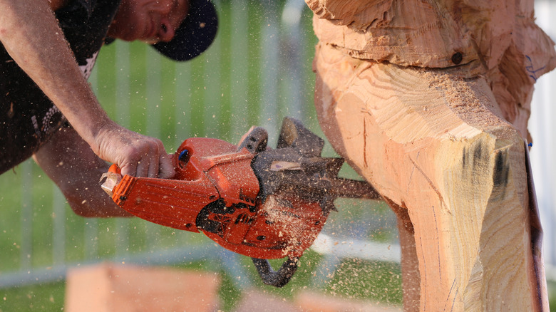man using chainsaw to carve a log, a tradition in Sedro-Woolley