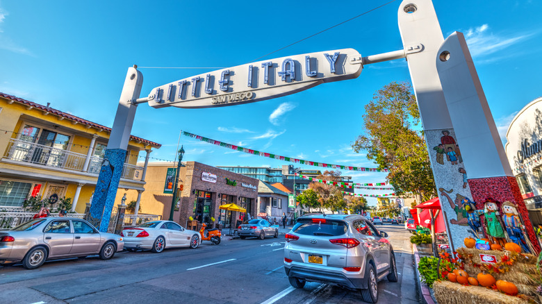 San Diego's "Little Italy" overhead sign surrounded by storefronts and autumn decor.