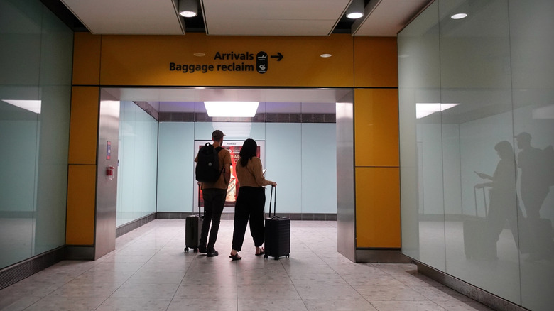 Travelers passing the baggage reclaim area of an airport