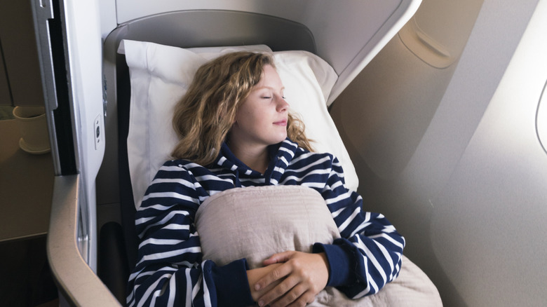 Woman sleeping in a large plane seat