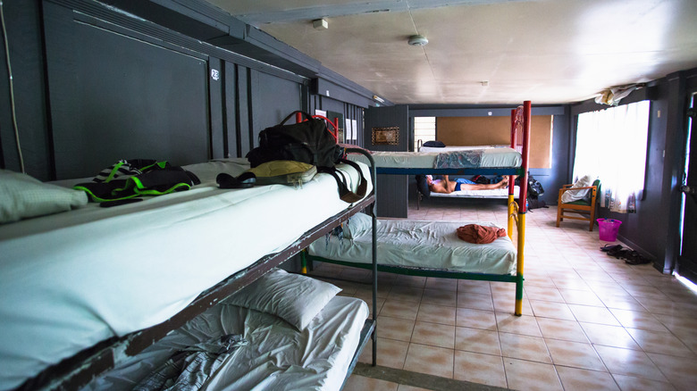 Hostel dorm with multiple beds and backpacks