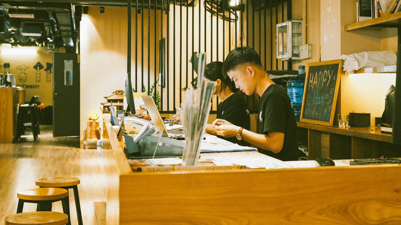 Receptionists behind counter at hostel