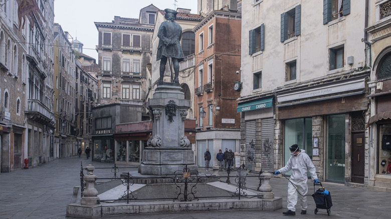A Venetian ecological operator maintains a monument in Campo San Bartolomeo