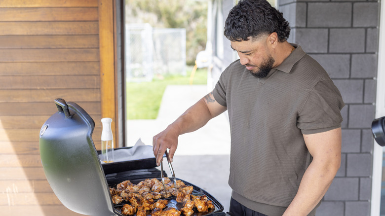 Māori man cooking a BBQ at home outdoor