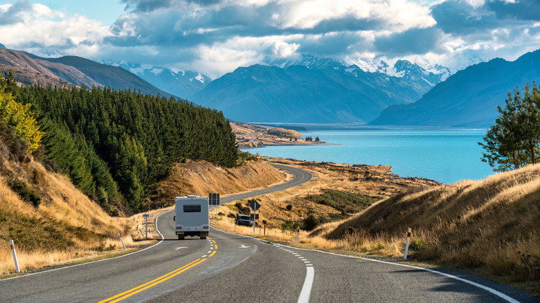 Scenic road trip  over winding road with motorhome driving alongside Lake Pukaki on sunny day at Peters lookout, New Zealand