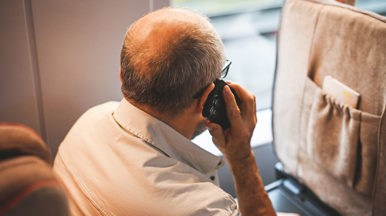 Elderly man talking on the phone while commuting