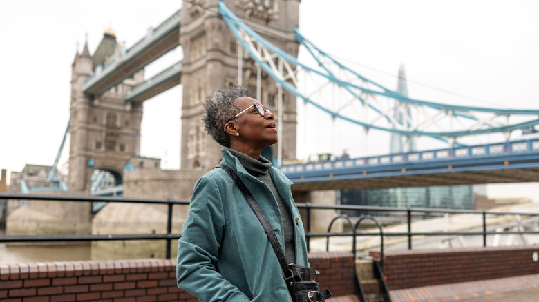 Elderly black woman in a teal jacket exploring London