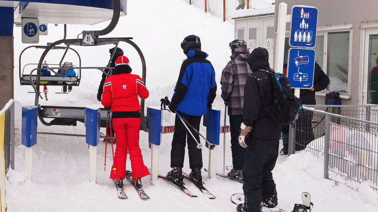 Skiers and snowboarders waiting to get on a chairlift