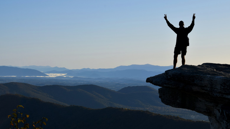 Silhouette of a man standing on McAfee Knob ledge at sunrise on the Appalachian Trail in Virginia