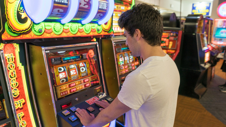 Young man in an arcade gambling on slot machines in Blackpool